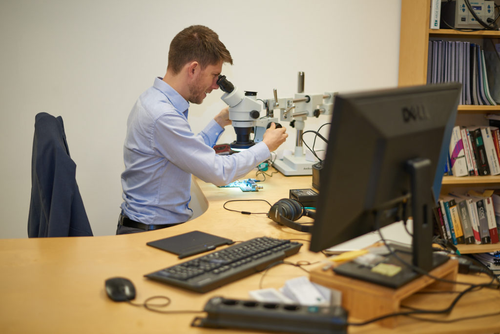 Reinhard Kugler looking trough a microscope.