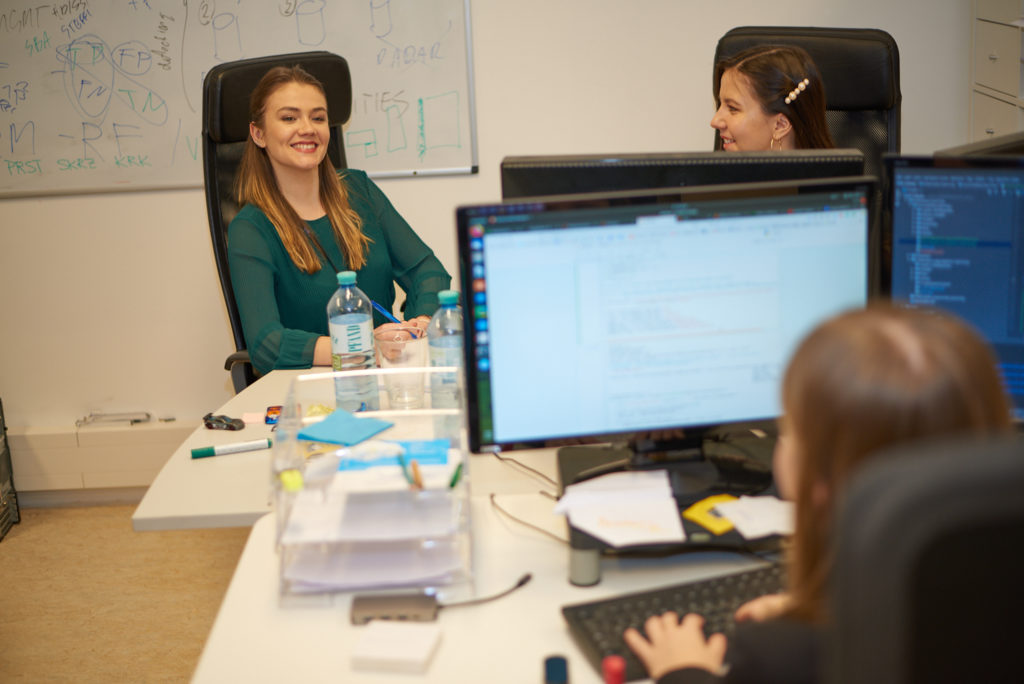 The team in the office sitting on their desks.