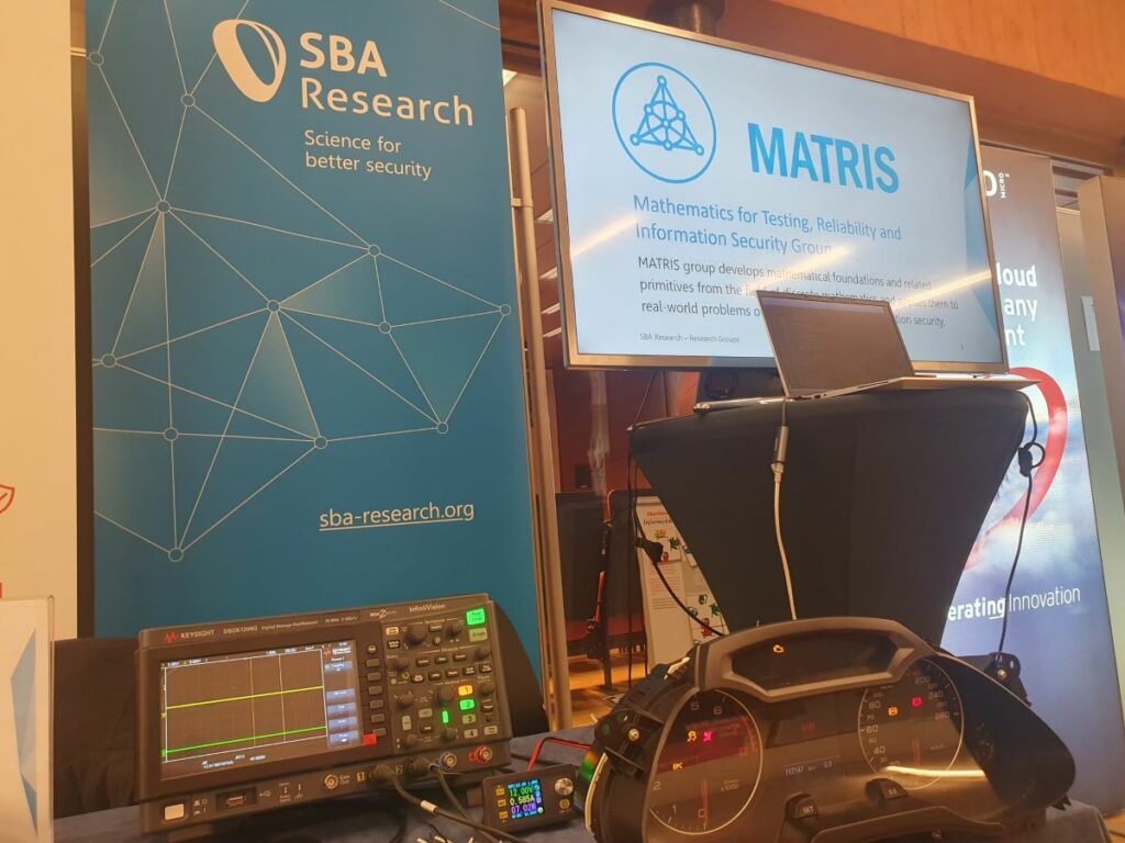 The SBA Research information booth with a screen showing the Matris logo