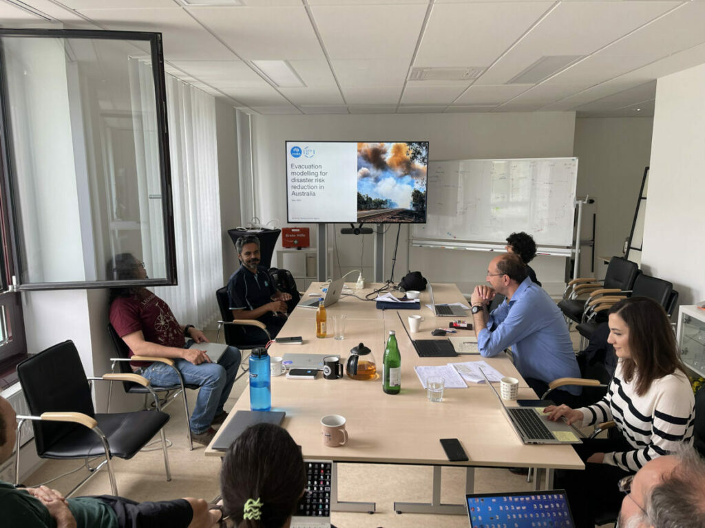 Research talk in meeting room with eight people sitting at a table