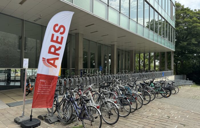 ARES 2025 beach flag and a lot of bikes in front of university Ghent campus