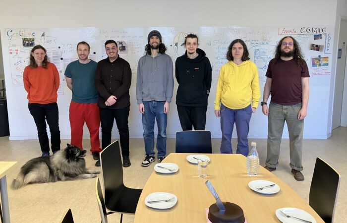 Damast Research Group in front of white wall in the social room